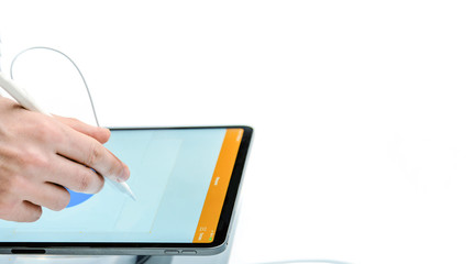 A hand with a stylus draws on a tablet. Digital technology. White isolated background. Close-up....