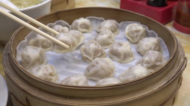 4K Motion of eating Xiao long bao soup dumpling buns with chopsticks in restaurant (Traditional Chinese food) in Taipei Taiwan 
