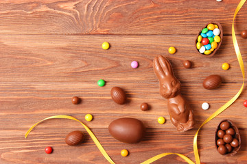  Easter composition with chocolate eggs and chocolate rabbit on wooden background, place for text 