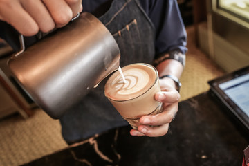 Fototapeta na wymiar Professional barista making caffe latte or cappuccino. Latte art.