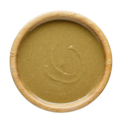 Natural paste from pumpkin seeds in wooden bowl isolated on white. Pumpkin urbech, pumpkin seed butter. Dagestani useful delicacy.  Top view.