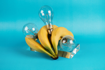 Fototapeta premium Different kinds of fruit and electric bulbs on blue background.