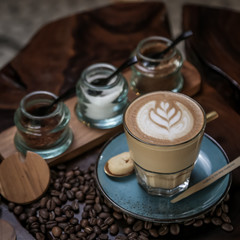 Hot Coffee Latte or Cappuccino cup with Coffee beans on the wooden table