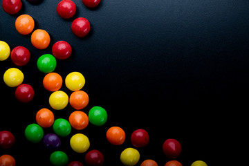 Kolorowe , soczyste cukierki na ciemnym tle.