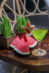 Green cocktail in martini glass with watermelon