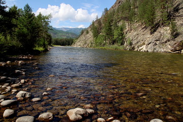 Siberian river Barguzin in the upper summer day in one of its turns between the slopes of the mountains