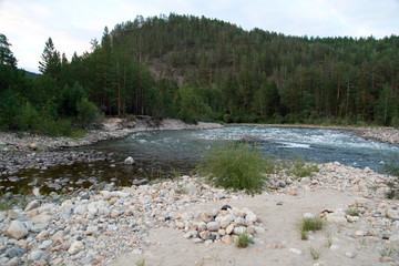 Siberian river Barguzin in the upper summer day in one of its turns between the slopes of the mountains