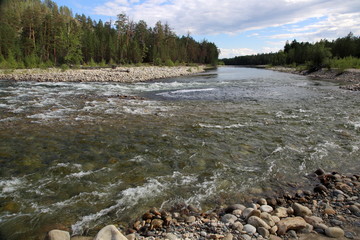 Siberian river Barguzin in the upper summer day in one of its turns between the slopes of the mountains