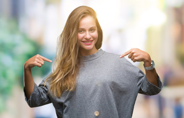 Young beautiful blonde woman over isolated background looking confident with smile on face,...