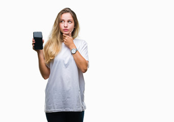 Fototapeta premium Young beautiful blonde woman showing screen of smartphone over isolated background serious face thinking about question, very confused idea