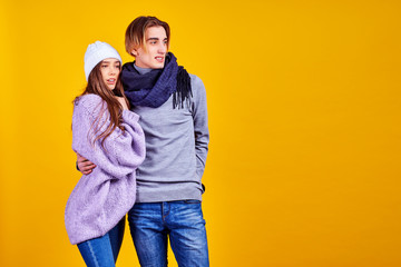 Obraz premium Couple in casual clothes posing in jeans type commercial fashion style on yellow wall