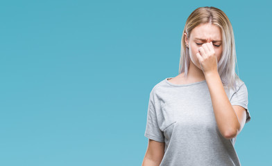 Young blonde woman over isolated background tired rubbing nose and eyes feeling fatigue and...