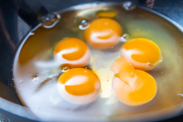 Broken eggs before cooking in a steel bowl