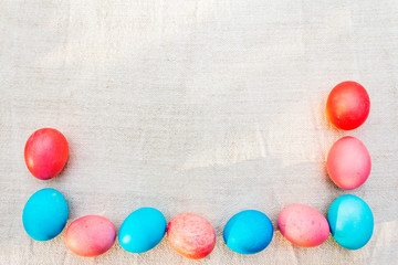 Obraz premium Easter concept pink (rosy) and blue eggs frame. On vintage cloth (linen) background