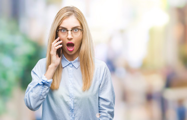 Young beautiful blonde business woman calling on smartphone over isolated background scared in shock with a surprise face, afraid and excited with fear expression