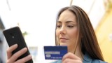 Serious woman paying with credit card online