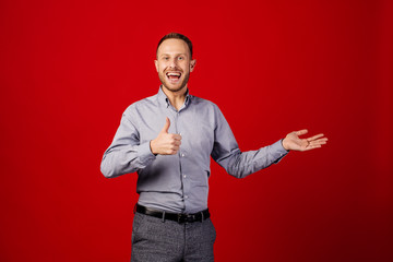 Naklejka premium funny man giving thumb up sign over red background. people and emotion concept.