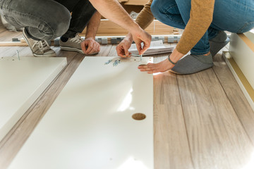 Couple assembling furniture in their new house