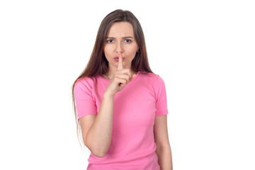 Shh! A young girl holds a finger near the lips showing a sign of silence. Portrait of a brunette woman with long hair on a white background.