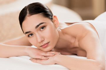 Obraz na płótnie Canvas beautiful asian woman resting and looking at camera at spa