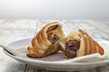 brioche spezzata pasta sfoglia con crema di nocciole nel piatto fronte