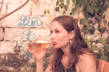 Junge Frau trinkt ein Bier im Künstlerviertel Getsemani in Cartagena, Kolumbien