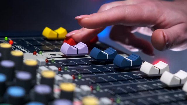 DJ at the mixing console in a nightclub. Musical player for tuning of stage. Close-up.