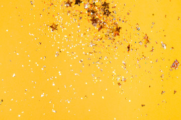 Colorful yellow confetti background. Vibrant and holiday. Top view, flat lay.