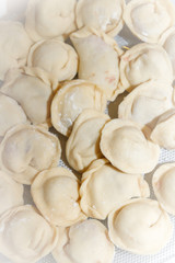 Raw and fresh dumplings lie on a glass plate
