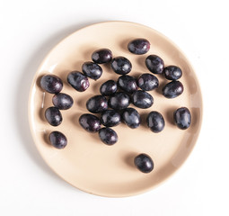 Black grapes on a plate.