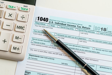 New 2019 IRS 1040 tax form, instructions, pen and calculator