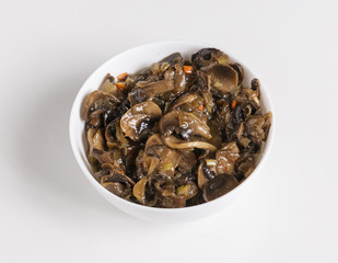 Fried mushrooms in a plate on a white background.