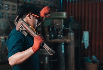 Engineer taking a break while working and wiping perspiration from his head with his safety gloves