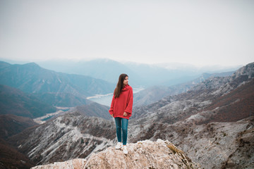 Beautiful Young Girl in a cosy red sweater on Mountain top
