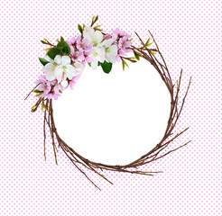 Round wreath from dry twigs with spring branches of peach and apple flowers
