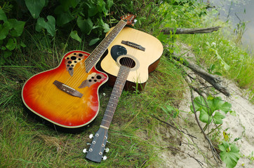 Two acoustic guitars on the river bank