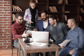 group of designers and photographers use a tablet computer for their work