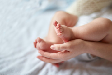 Mother's hands carefully keeping baby's foot with tenderness