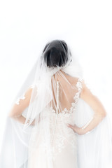 The bride is standing back in studio on white background