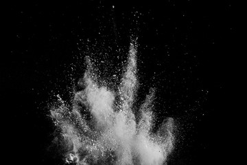 White powder explosion isolated on black background. White dust particles splash.Color Holi...