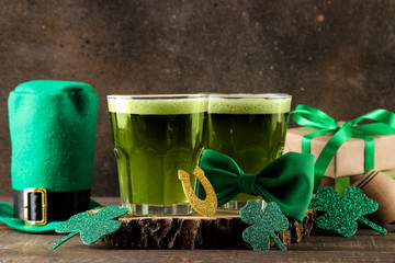 St.Patrick 's Day. celebration. green beer, leprechaun hat, coins, bow tie and clover on a brown...