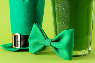 St.Patrick 's Day. celebration. green beer, bow tie and leprechaun hat on a bright green...