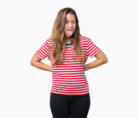 Fototapeta premium Young beautiful brunette woman wearing stripes t-shirt over isolated background sticking tongue out happy with funny expression. Emotion concept.