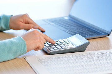 Businesswoman accounting with calculator at office