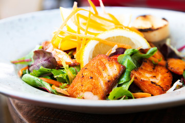 grilled salmon and lemon - french cuisine dish with tomato and salmon