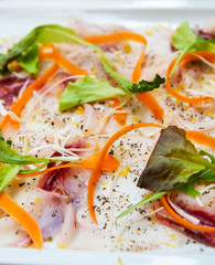 Fresh Sliced raw beef meat with leaf lettuce on the table