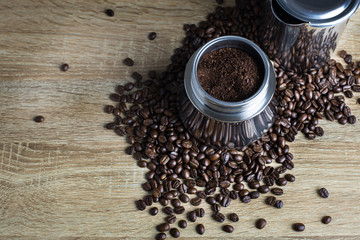 Stainless Steel moka pot and coffee beans on wooden table