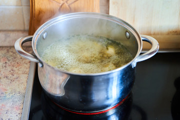 Cooking broth in a saucepan on a glass-ceramic plate