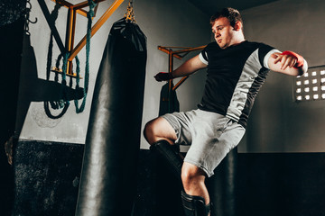 Fighter man training in heavy bag at gym
