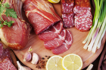 Ham, sausage and vegetables on the kitchen board